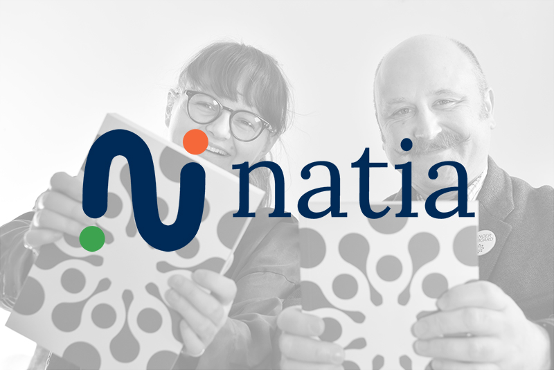 two people holding book with natia logo ontop